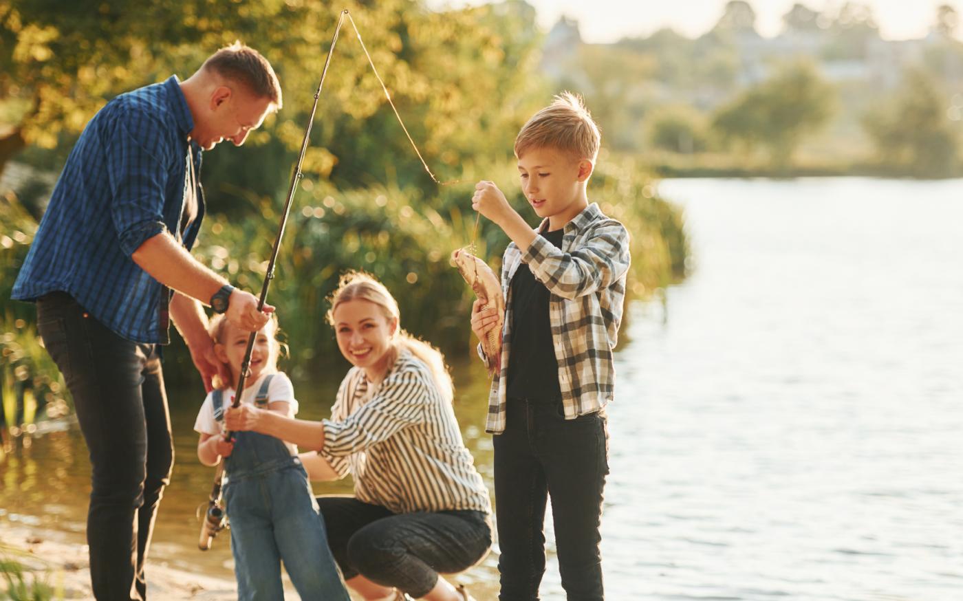 famille de quatre personnes pêchant au bord d'un lac