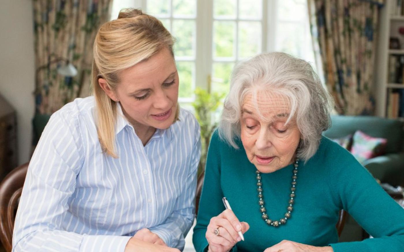 Jeune femme aidant une femme plus âgée avec les finances